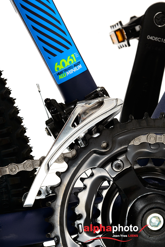 Packshot produit d'un vélo tout terrain photographié en studio sur fond blanc pour du packshot publicitaire. Gros plan sur le dérailleur avant.